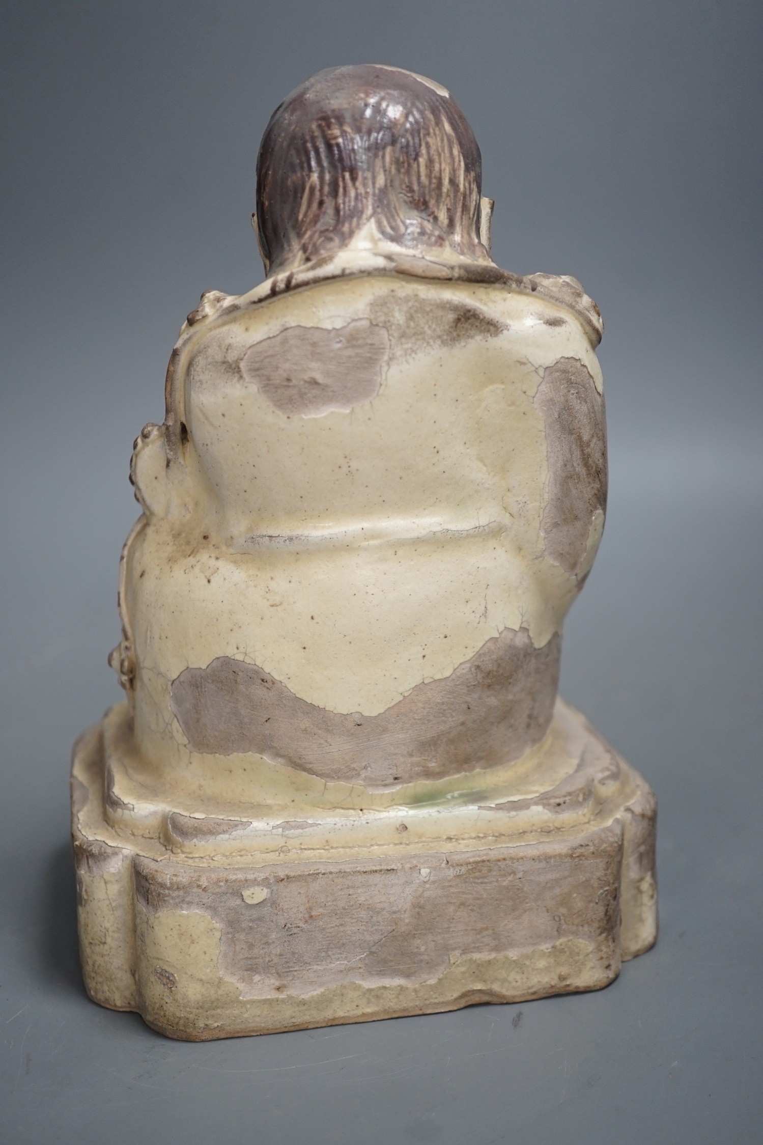 A Chinese Cizhou seated figure of Liu Hai, possibly Ming dynasty, 21cms high, glaze flaking